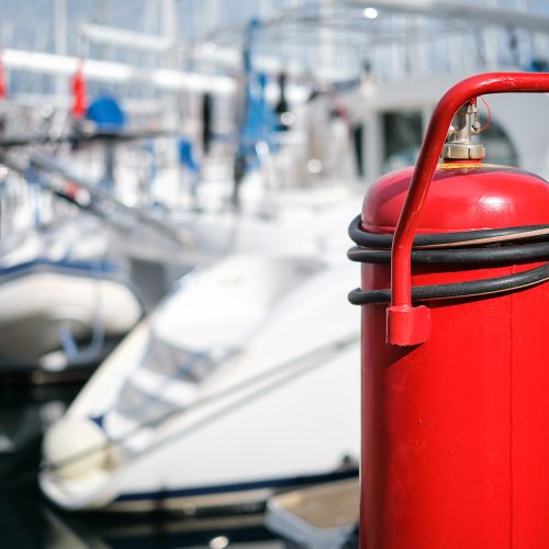 Fire extinguisher close-up on the mooring of the yacht club